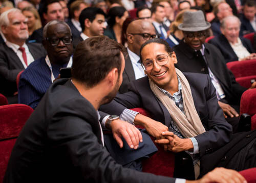 Men smiling and talking at business conference