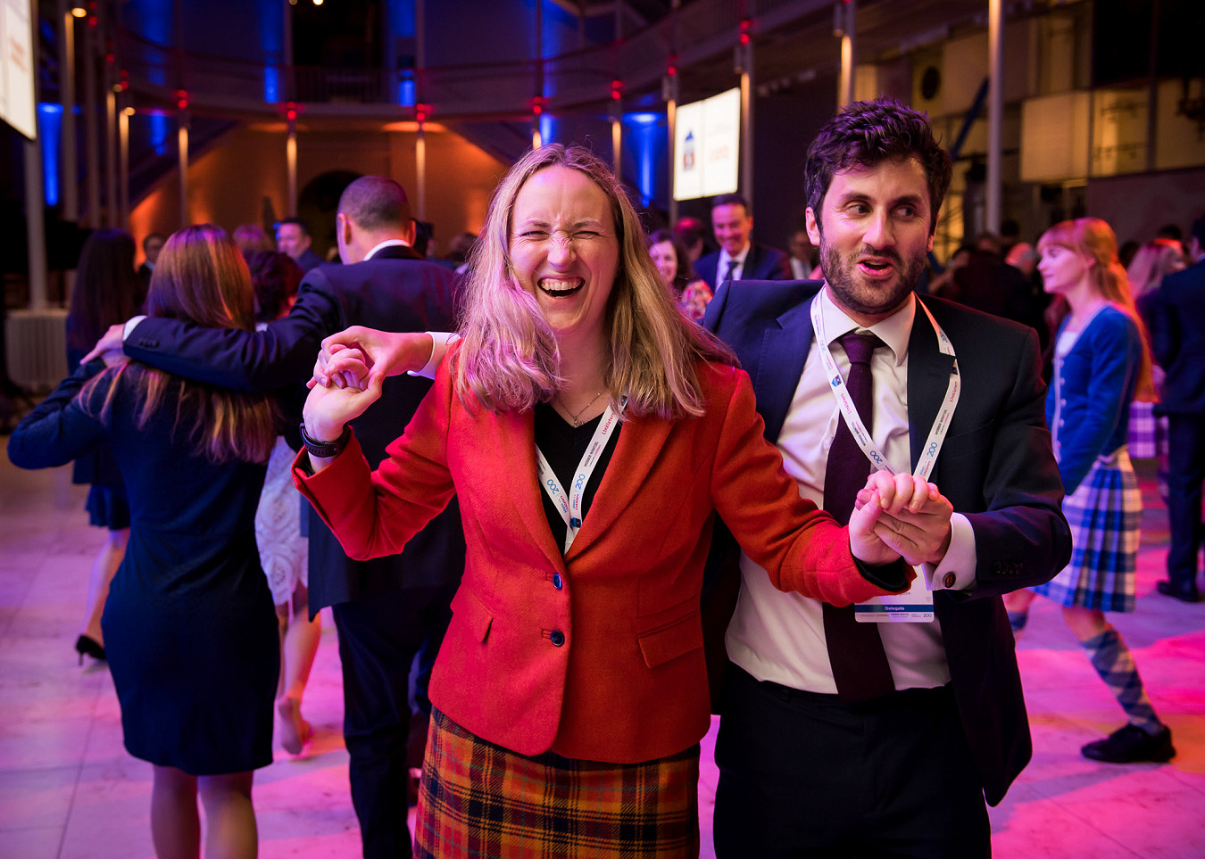 A woman laughs as she and others dance at a ceilidh at the National Museum in Edinburgh