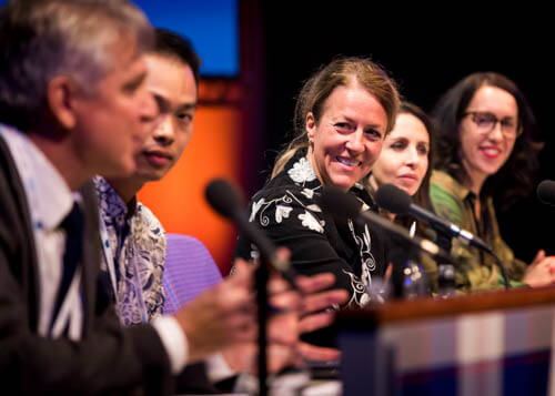 Woman smiling as part of a panel discussion at a conference